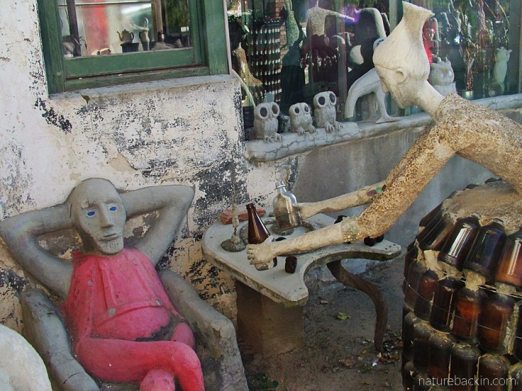 Hostess offering a man a drink, Camel Yard, Owl House, South Africa
